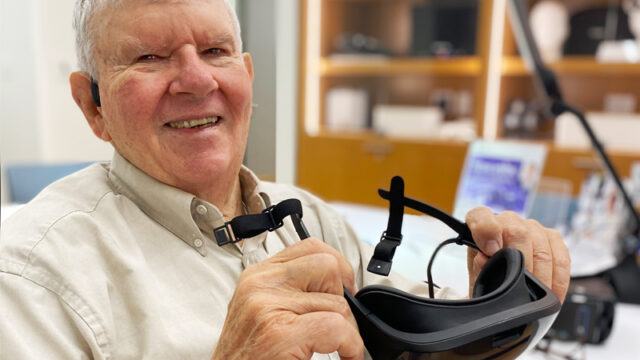 A smiling senior man using assistive technology.