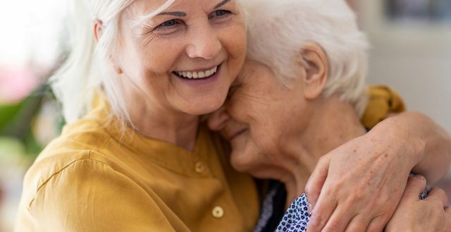 Family caregiver embracing the elderly parent