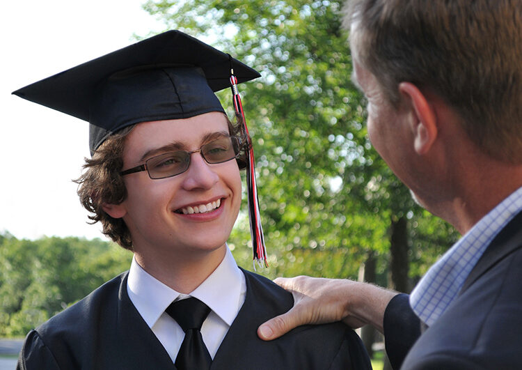 Father congratulating son at Graduation