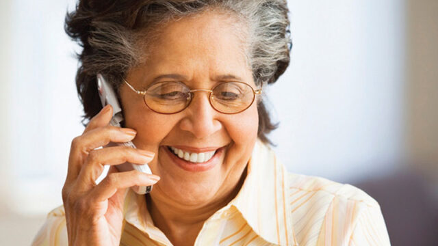 A smiling elderly lady on the phone.
