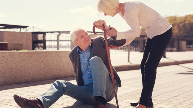 Fall Prevention: a senior gentleman struggling to get up.